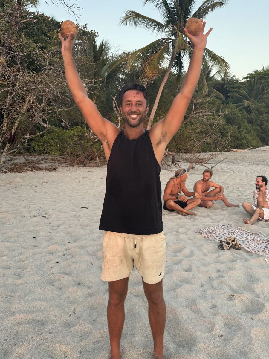 Beau on the beach in Costa Rica, arms raised